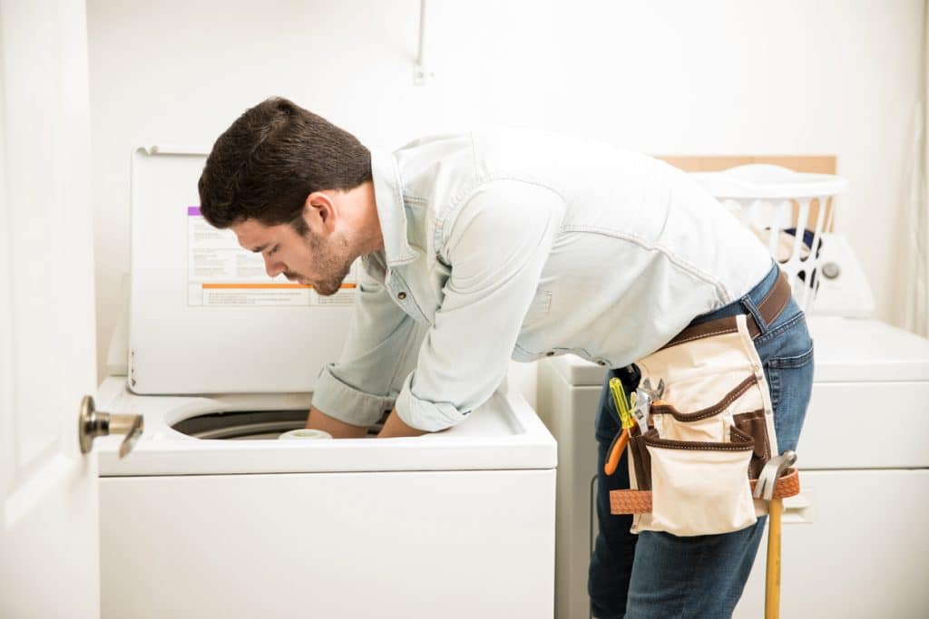 technician fixing a washer and dryer