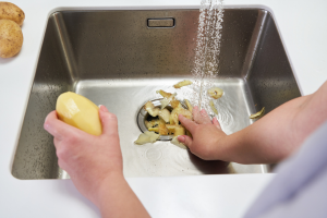 pealing potatoes in sink